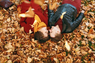 En iyi aşk kadın, düşen yapraklar sonbaharda Şehir Park açık havada yatan elele birbirilerine bakan gözlerin kapalı adamla genç neşeli mutlu çift görüntüleyin. Aşk ilişki aile yaşam tarzı kavramı