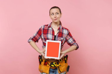 Kit araçları kemer çeşitli aletleri tam kadınla pembe arka plan izole boş siyah Boþ ekran ekran dokunmatik ekran ile tablet pc bilgisayar tutun. Kadın erkek işi. Yenileme kavramı