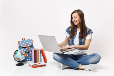 Tutan genç gülümseyen kadın öğrenci portresi küre oturan dizüstü pc bilgisayar kullanan sırt çantası, beyaz arka plan üzerinde izole okul kitapları. Lise Üniversite kavramı kolej eğitim