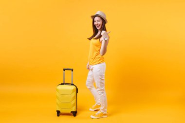 Seyahat etmek turist kadın yaz rahat kıyafetler, sarı turuncu arka plan üzerinde izole çanta şapka. Hafta sonu kaçış üzerinde seyahat için yurt kadın yolcu. Hava uçuş yolculuk kavramı