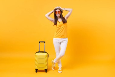 Seyahat etmek turist kadın yaz rahat kıyafetler, sarı turuncu arka plan üzerinde izole çanta şapka. Hafta sonu kaçış üzerinde seyahat için yurt kadın yolcu. Hava uçuş yolculuk kavramı