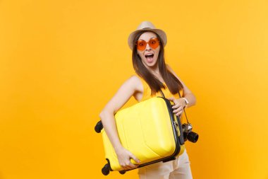 Seyahat etmek turist kadın yaz rahat kıyafetler, sarı turuncu arka plan üzerinde izole çanta şapka. Hafta sonu kaçış üzerinde seyahat için yurt kadın yolcu. Hava uçuş yolculuk kavramı
