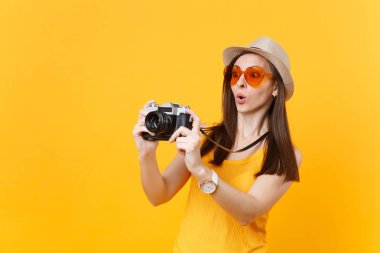 Turist kadın yaz rahat kıyafetler, şapka sarı arka plan üzerinde izole retro vintage fotoğraf makinesinde resim çekmek. Hafta sonu kaçış üzerinde seyahat için yurt kız. Hava uçuş yolculuk kavramı