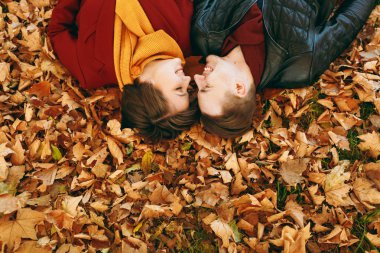 Üstten görünüm portre genç mutlu iki kadın sevmek, Kapalı gözler her sonbahar Şehir Park açık havada düşen yapraklar yatan karşı karşıya olan adam sonra gülümseyerek. Aşk ilişki aile yaşam tarzı kavramı