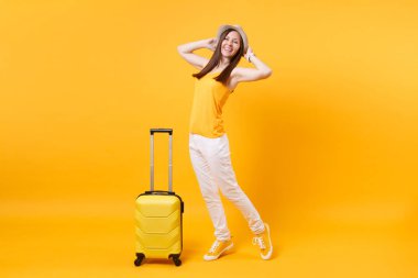 Seyahat etmek turist kadın yaz rahat kıyafetler, sarı turuncu arka plan üzerinde izole çanta şapka. Hafta sonu kaçış üzerinde seyahat için yurt kadın yolcu. Hava uçuş yolculuk kavramı