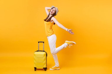 Seyahat etmek turist kadın yaz rahat kıyafetler, sarı turuncu arka plan üzerinde izole çanta şapka. Hafta sonu kaçış üzerinde seyahat için yurt kadın yolcu. Hava uçuş yolculuk kavramı