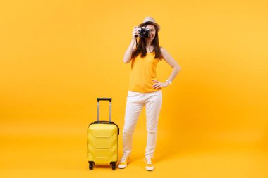 Yaz rahat kıyafetler çanta, retro vintage fotoğraf makinesi üzerinde sarı turuncu arka plan izole kadın turist. Hafta sonu kaçış üzerinde seyahat için yurt dışında seyahat yolcu. Hava uçuş kavramı
