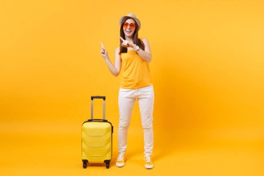 Seyahat etmek turist kadın yaz rahat kıyafetler, sarı turuncu arka plan üzerinde izole çanta şapka. Hafta sonu kaçış üzerinde seyahat için yurt kadın yolcu. Hava uçuş yolculuk kavramı