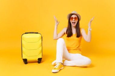 Eller izole sarı turuncu arka plan üzerinde yayılan eğlenceli turist kadın yaz rahat kıyafetler, çanta, şapka sit. Hafta sonu kaçış üzerinde seyahat için yurt kız. Hava uçuş kavramı