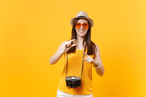 旅游妇女在夏季休闲服装 帽子持有比特币 金属硬币的黄金颜色孤立的黄色橙色背景 在周末出游的女性旅行 航空飞行概念 — 图库照片