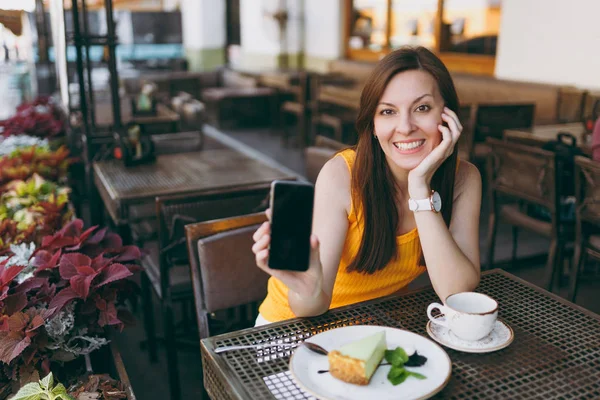 Frau Straßencafé Sitzt Tisch Mit Tee Kuchen Hält Handy Mit — Stockfoto