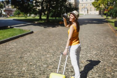 Güzel seyahat etmek turist kadın çanta sarı giysili şehirde açık yürüyüş retro vintage fotoğraf makinesinde fotoğraf çekmek. Hafta sonu kaçamağı yurt kız. Turizm yolculuk yaşam tarzı