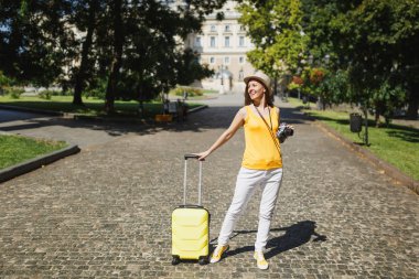 Mutlu traveler turist kadın çanta Sarı rahat kıyafetler şapkalı, retro vintage fotoğraf makinesi yürüyerek şehir açık. Hafta sonu kaçamağı üzerinde seyahat için yurt kız. Turizm yolculuk yaşam tarzı