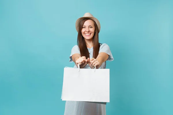 肖像画は 夏のドレス 麦わら帽子のパッケージ袋を保持している購入ショッピング青のパステル調の背景に分離した後に笑顔の美しい白人女性を興奮させた 広告のためのスペースをコピーします — ストック写真