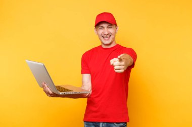 Sarı turuncu arka plan üzerinde izole teslimatçı. Profesyonel erkek çalışan kurye kırmızı şapkalı, dizüstü pc bilgisayarda yazarak çalışma tutan t-shirt. Hizmet anlayışı. Kopya alanı reklam için