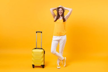 Seyahat etmek turist kadın yaz rahat kıyafetler, sarı turuncu arka plan üzerinde izole çanta şapka. Hafta sonu kaçış üzerinde seyahat için yurt kadın yolcu. Hava uçuş yolculuk kavramı