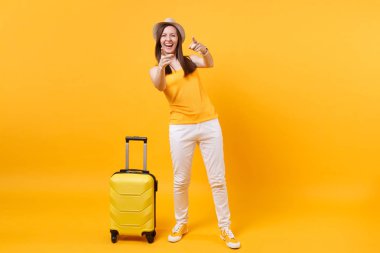 Seyahat etmek turist kadın yaz rahat kıyafetler, sarı turuncu arka plan üzerinde izole çanta şapka. Hafta sonu kaçış üzerinde seyahat için yurt kadın yolcu. Hava uçuş yolculuk kavramı