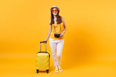 Seyahat etmek turist kadın yaz rahat kıyafetler, boynunda sarı turuncu arka plan üzerinde izole kulaklık ile şapka. Hafta sonu kaçış üzerinde seyahat için yurt dışında seyahat yolcu. Hava uçuş yolculuk kavramı