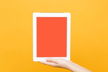 Kadın bekle el ile metin veya resim, turuncu arka plan sarı eğilimleri izole çalışma alanı için yer boş boş ekran ile tablet pc pad kapatın. Teknoloji kavramı. Kopyalama alanı reklam