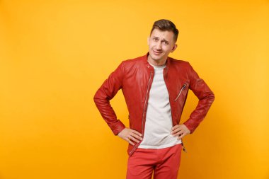 Portre vogue kuşkucu genç adam 25-30 yıl içinde kırmızı deri ceket, t-shirt üzerinde izole parlak sarı eğilimleri arka plan ayakta üzgün. İnsanlar samimi duygular yaşam tarzı kavramı. Reklam alanı