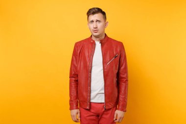 Portre vogue 25-30 yıl içinde kırmızı deri ceket, t-shirt üzerinde izole parlak sarı eğilimleri arka plan ayakta yakışıklı genç adam üzgün. İnsanlar samimi duygular yaşam tarzı kavramı. Reklam alanı