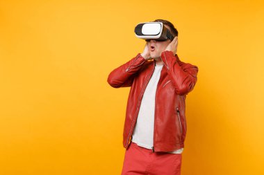 Portre vogue kırmızı deri ceketli genç adam şok, parlak sarı eğilimleri arka plan üzerinde duran kulaklık arıyorum t-shirt izole. İnsanlar samimi duygular yaşam tarzı kavramı. Reklam alanı