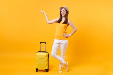 Seyahat etmek turist kadın yaz rahat kıyafetler, sarı turuncu arka plan üzerinde izole çanta şapka. Hafta sonu kaçış üzerinde seyahat için yurt kadın yolcu. Hava uçuş yolculuk kavramı
