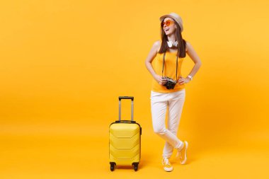 Seyahat etmek turist kadın yaz rahat kıyafetler, boynunda sarı turuncu arka plan üzerinde izole kulaklık ile şapka. Hafta sonu kaçış üzerinde seyahat için yurt dışında seyahat yolcu. Hava uçuş yolculuk kavramı