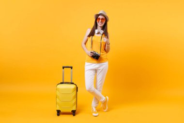 Seyahat etmek turist kadın yaz rahat kıyafetler, boynunda sarı turuncu arka plan üzerinde izole kulaklık ile şapka. Hafta sonu kaçış üzerinde seyahat için yurt dışında seyahat yolcu. Hava uçuş yolculuk kavramı