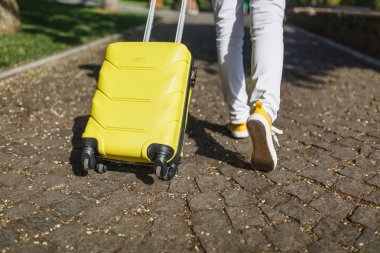 Sarı çanta Şehir Parkı açık yolu üzerinde yürüme ile görüntü seyahat etmek turist kadın rahat kıyafetler içinde kırpılmış. Hafta sonu kaçamağı üzerinde seyahat için yurt kız. Turizm yolculuk yaşam tarzı kavramı