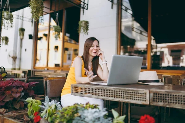 Açık havada sokak kafe Cafe modern dizüstü pc bilgisayar üzerinde çalışan, restoranda serbest zaman sırasında rahatlatıcı masada oturan kadın. Mobil ofis yazında. Yaşam tarzı serbest iş kavramı