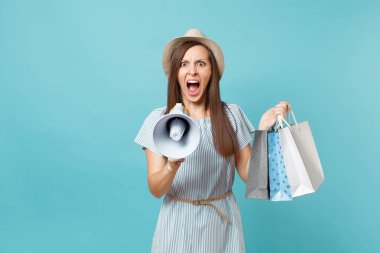Yaz elbiseli kadın portre, şapka ile paketleri çanta holding alışveriş alışveriş sonra çığlık megafon, pastel mavi arka plan üzerinde izole indirim duyurdu Satılık. Kopya alanı reklam için
