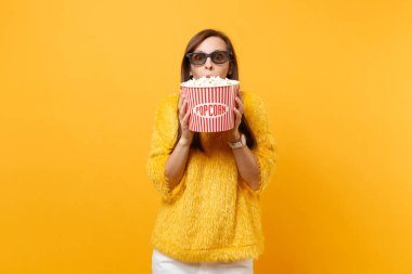 Film film izlerken, kova patlamış mısır parlak sarı arka plan üzerinde izole ağzıyla kapsayan 3d IMAX gözlüklü şok genç kız portresi. Sinema, yaşam kavramı insanların samimi duygular