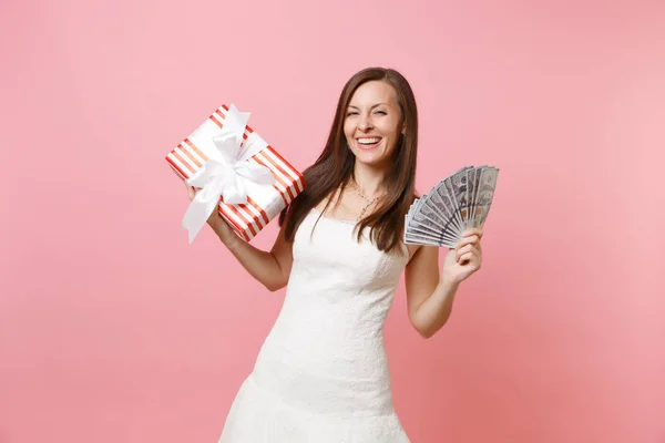 ギフト 現在ピンクのパステル調の背景に分離された赤いボックスの白いウェディング ドレス ホールド バンドル多くの花嫁の女性を笑いの肖像画 結婚式のお祝いのコンセプト コピー スペース — ストック写真