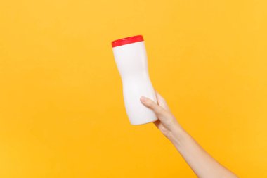 Erkek yakından elinde beyaz temizleme boş boş plastik şişe çanta üzerinde sarı arka plan izole atıştırmalık yiyecek için basılı tutun. Ambalaj şablon mockup. Teslim hizmet anlayışı. Uzay reklam alanı Kopyala