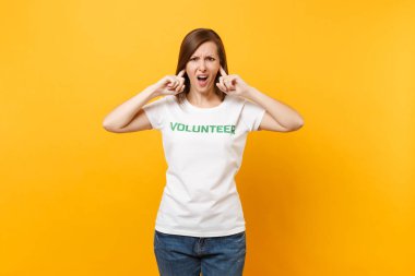 Üzgün üzgün şok genç kadın izole sarı arka plan üzerinde beyaz t-shirt ile yazılı yazıt yeşil başlık gönüllü olarak portresi. Gönüllü ücretsiz destek yardım, sadaka grace iş kavramı
