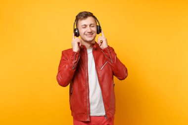 Portre vogue mutlu eğlenceli genç adam kırmızı deri ceket, t-shirt üzerinde arka plan parlak sarı eğilimleri izole kulaklık müzik dinlemek. İnsanlar samimi duygular yaşam tarzı kavramı. Reklam alanı