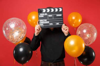 Siyah gömlek holding saklanarak Klaket kırmızı arka plan hava balonu üzerinde yapma klasik siyah film ile yüz kapsayan genç adam. Sevgililer günü, Yeni Yılınız kutlu olsun Doğum günü mockup tatil parti konsept