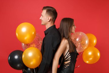 Parlak kırmızı arka plan hava balonu üzerinde kutluyor Doğum günü tatil partisi izole siyah giysili genç çift çarpıcı. St. Valentine's Dünya Kadınlar Günü mutlu yeni yıl 2019 kavramı.