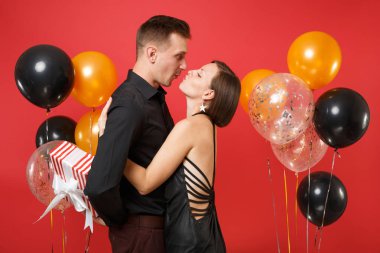 Hediye kutusu kutluyor Doğum günü tatil partisi parlak kırmızı arka plan hava balonu üzerinde izole St. Valentine Uluslararası Kadınlar Günü mutlu yeni yıl 2019 kavramı siyah giysili genç çift tutun.