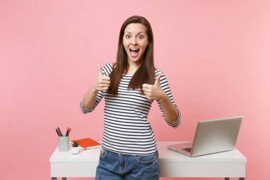 Genç kadında rahat kıyafetler ile laptop pastel pembe izole iş ayakta beyaz Resepsiyon yakınındaki Yaşasın gösterilen heyecanlı. Başarı iş kariyer kavramı. Kopya alanı reklam için