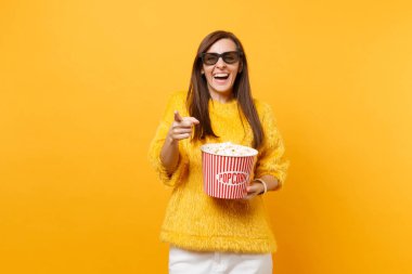 İşaret parmağı, film film izlerken, kova patlamış mısır parlak sarı arka plan üzerinde izole bekletme 3d IMAX gözlüklü genç kız gülüyor. Sinema, yaşam kavramı insanların samimi duygular