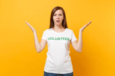 Üzgün üzgün şok genç kadın izole sarı arka plan üzerinde beyaz t-shirt ile yazılı yazıt yeşil başlık gönüllü olarak portresi. Gönüllü ücretsiz destek yardım, sadaka grace iş kavramı