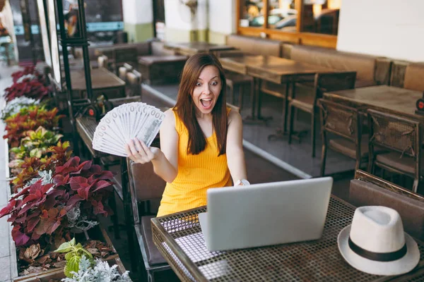 Frau Straßencafé Sitzt Mit Modernem Laptop Hält Ein Bündel Dollarnoten — Stockfoto