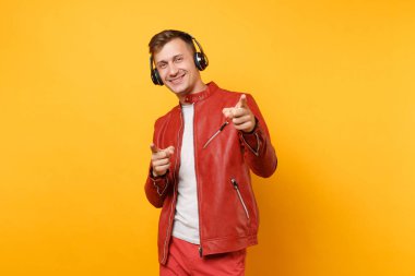 Portre vogue mutlu eğlenceli genç adam kırmızı deri ceket, t-shirt üzerinde arka plan parlak sarı eğilimleri izole kulaklık müzik dinlemek. İnsanlar samimi duygular yaşam tarzı kavramı. Reklam alanı