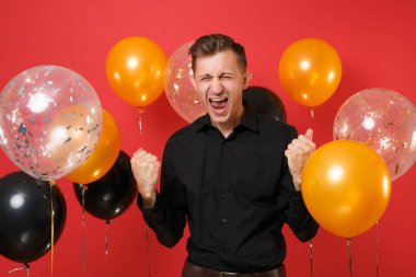 Kazanan kırmızı arka plan hava balonu üzerinde çığlık gibi klasik gömlek kenetlenmesi kutluyor çok memnun genç adam yumruk. St. Valentine's kadınların gün Happy New Year Doğum günü mockup tatil parti konsept