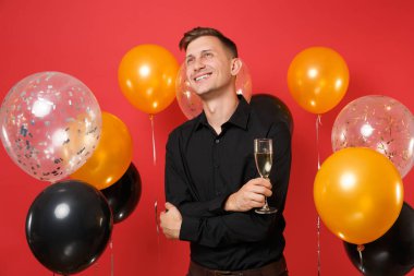 Parlak kırmızı arka plan hava balonu üzerinde ararken rüya gibi genç adam siyah klasik gömlek kadeh şampanya, holding. St. Valentine's, kadın gün Happy New Year Doğum günü mockup tatil parti konsept