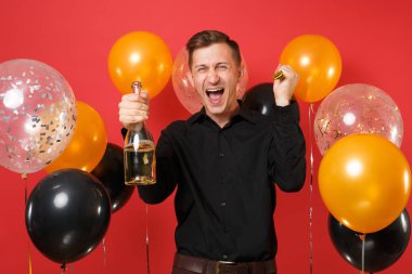 Şişe şampanya kırmızı arka plan hava balonları tutan boru oynama ile siyah klasik gömlek mutlu genç adam. St. Valentine's, kadınlar günü, mutlu yeni yıl Doğum günü mockup tatil parti konsept