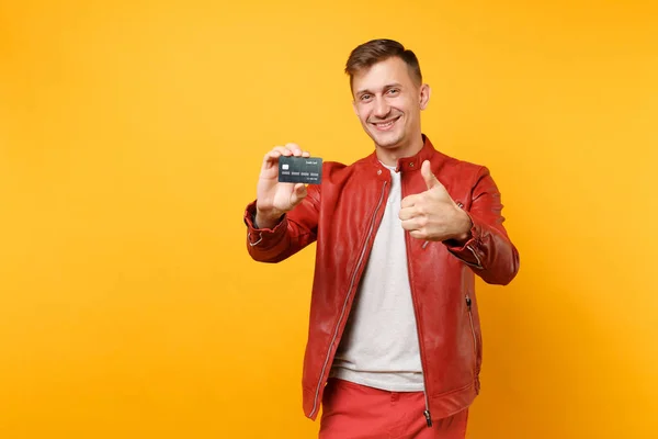肖像时尚微笑英俊的年轻男子在红色皮革夹克 T恤持有银行信用卡孤立的趋势黄色背景 人们真挚的情感生活理念 广告专区 — 图库照片