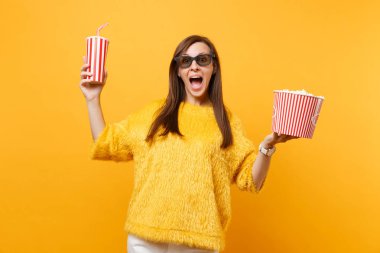 Mutlu genç kadın film film izlerken, kova patlamış mısır ve kola veya izole sarı zemin üzerine soda plastik bardak tutan 3d IMAX bardaklarda heyecanlı. İnsanlar sinema, samimi duygular yaşam tarzı